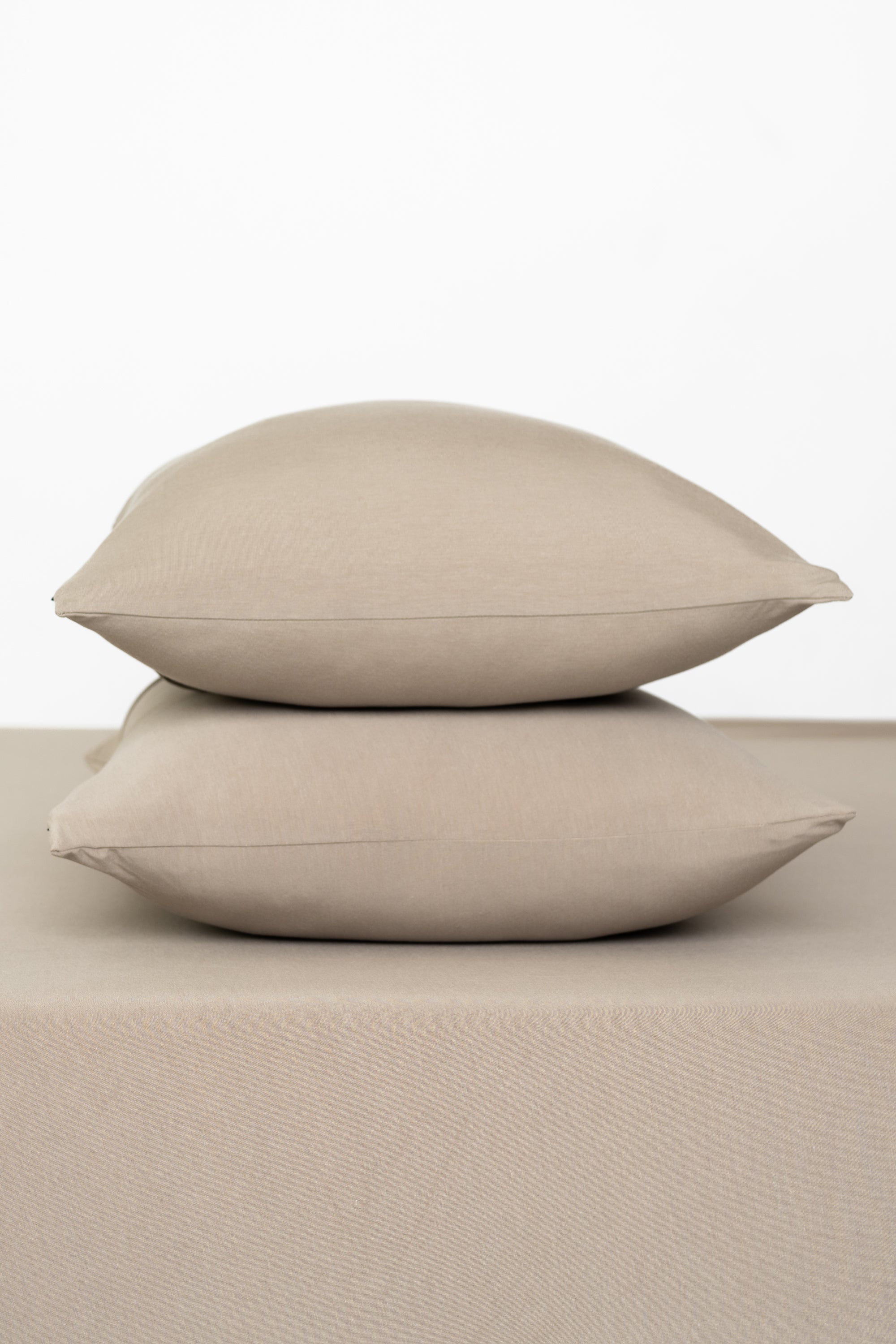 Fitted Sheet with Pillowcases in Almond. Showing 2 pillows stacked on a sheet