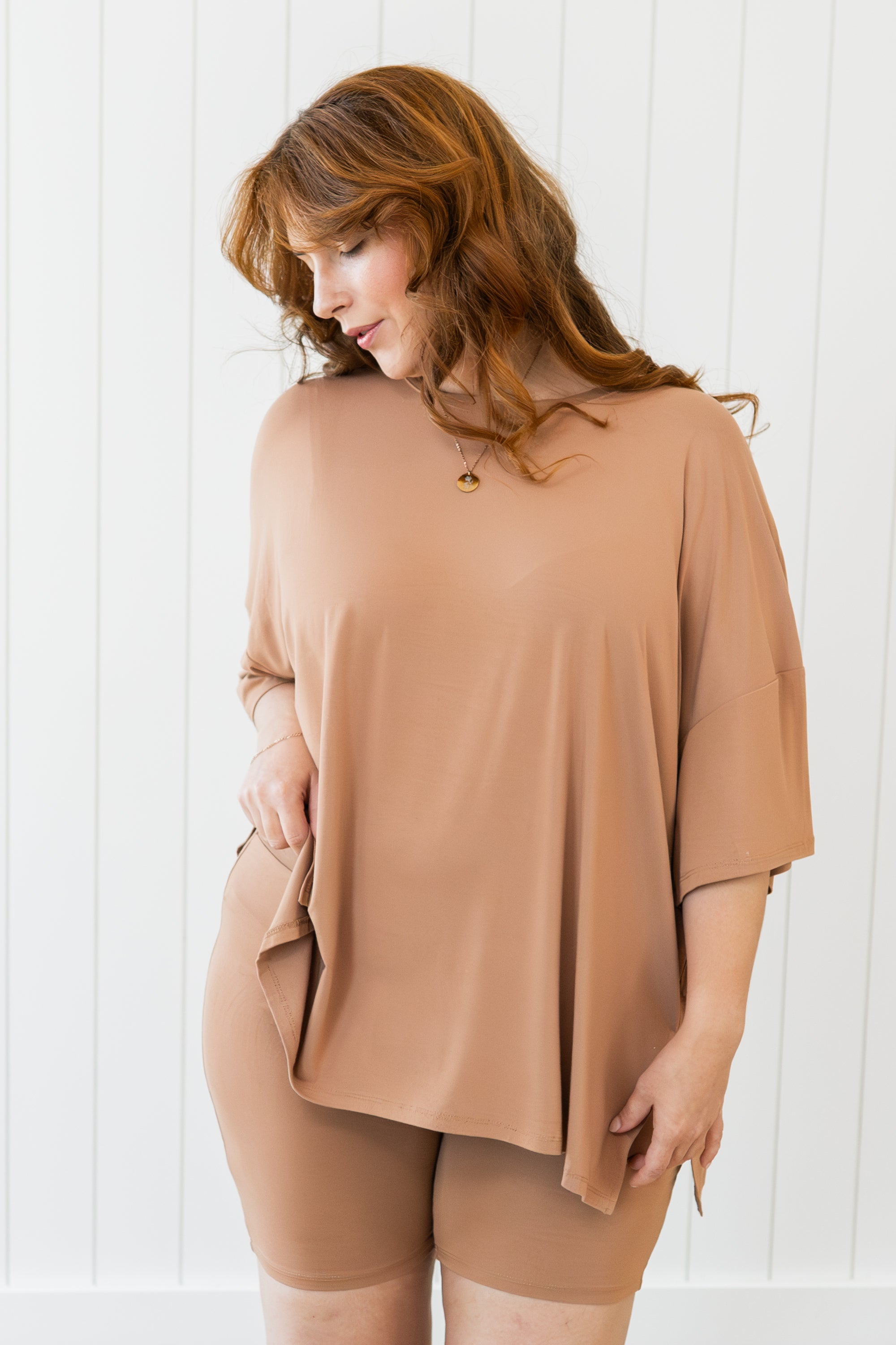 Woman wearing a tan outfit against a white background