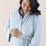 Expectant mother cradling her baby bump while wearing the Adult Robe in Storm