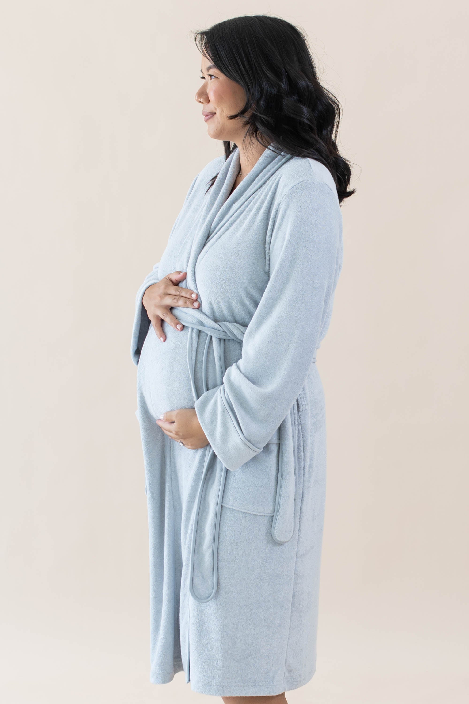 Expectant mother holding her baby bump while wearing the Adult Robe in Storm
