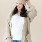 Woman modeling Chunky Knit Women's Oversized Cardigan in Almond and matching Pom Beanie