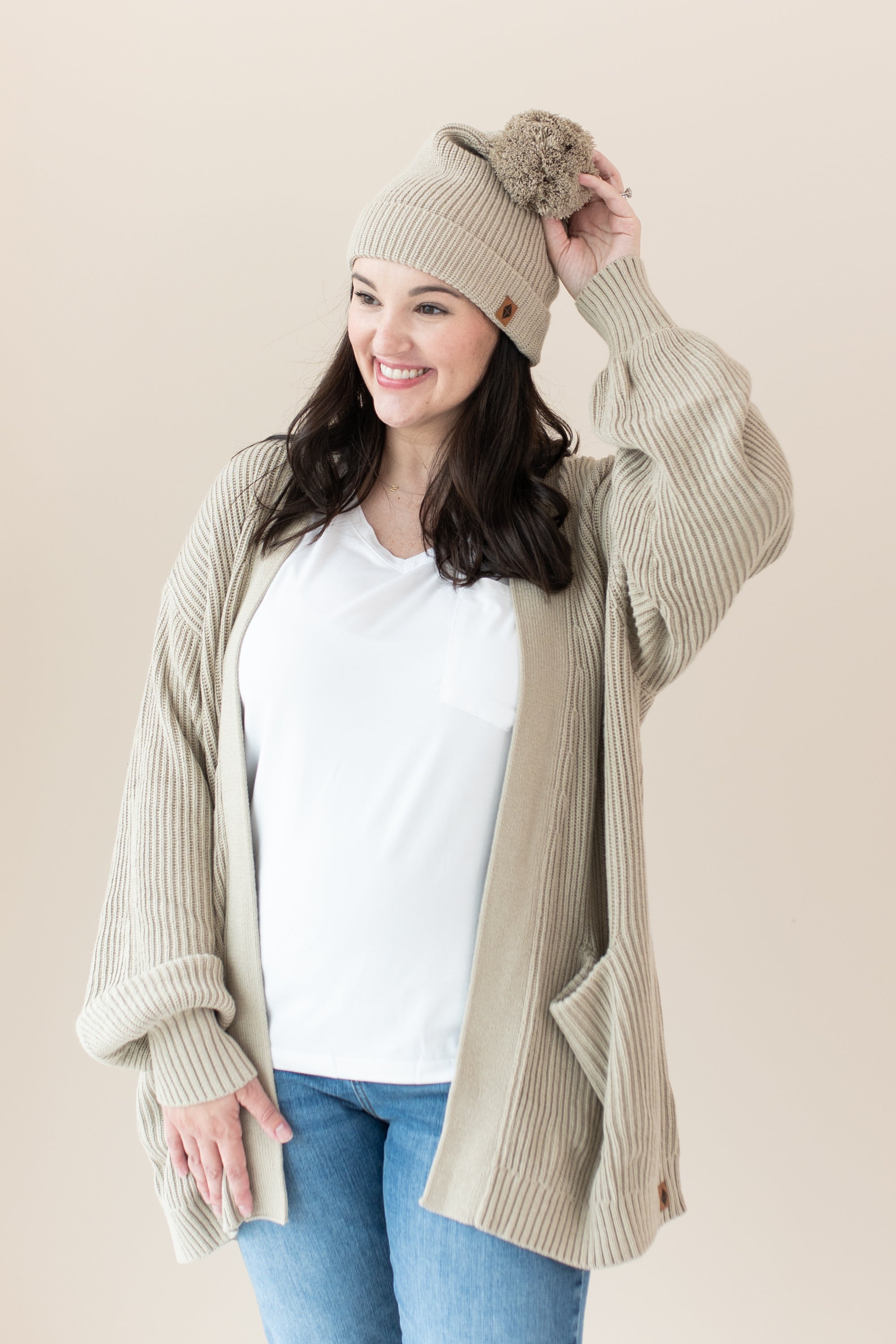 Woman modeling Chunky Knit Women's Oversized Cardigan in Almond and matching Pom Beanie
