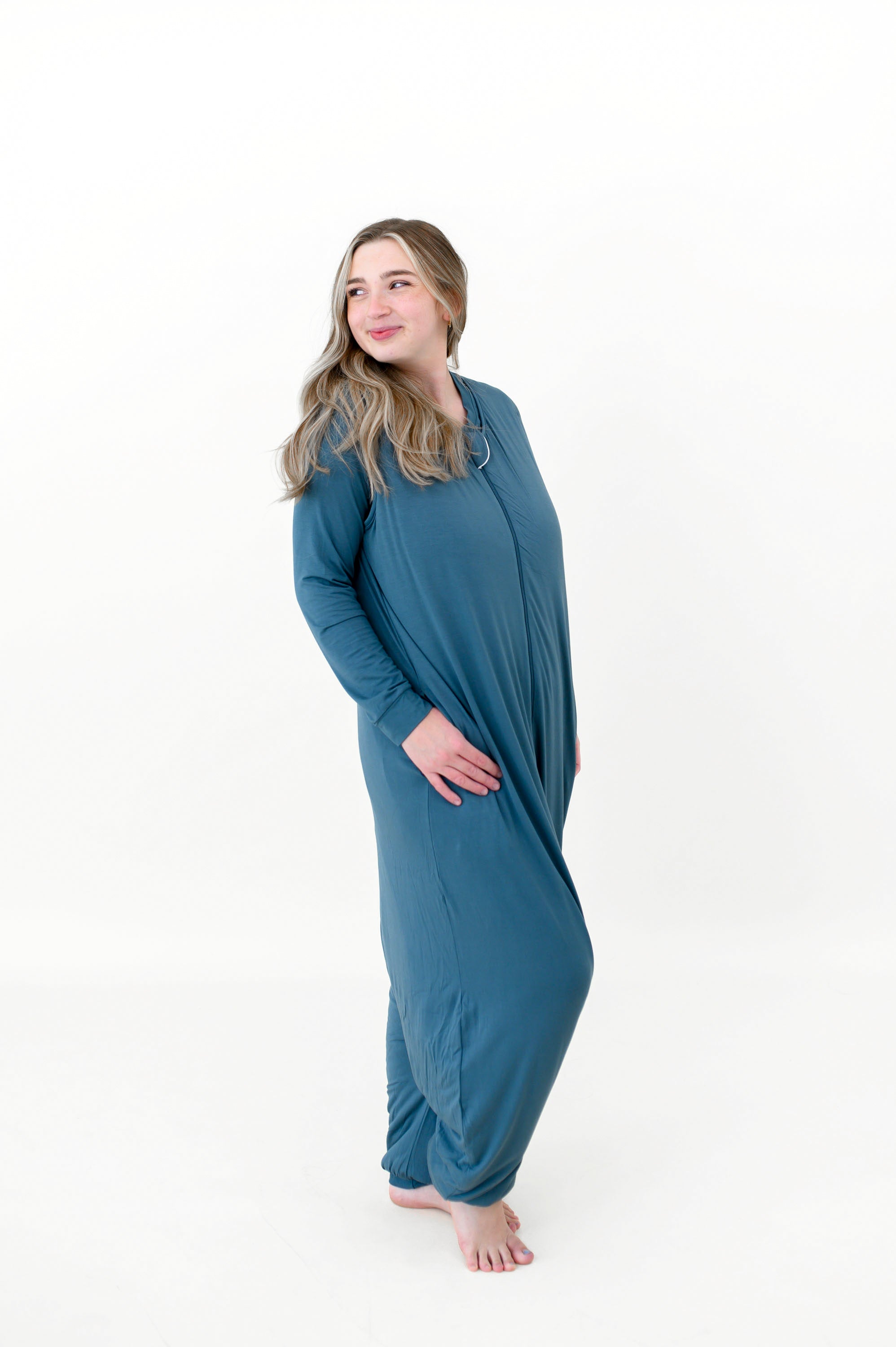 Model looking over her shoulder while wearing the Adult Sleep Bag Walker in Atlantic and smiling