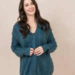 Smiling model wearing the Chunky Cable Knit Cardigan in Atlantic while buttoned up
