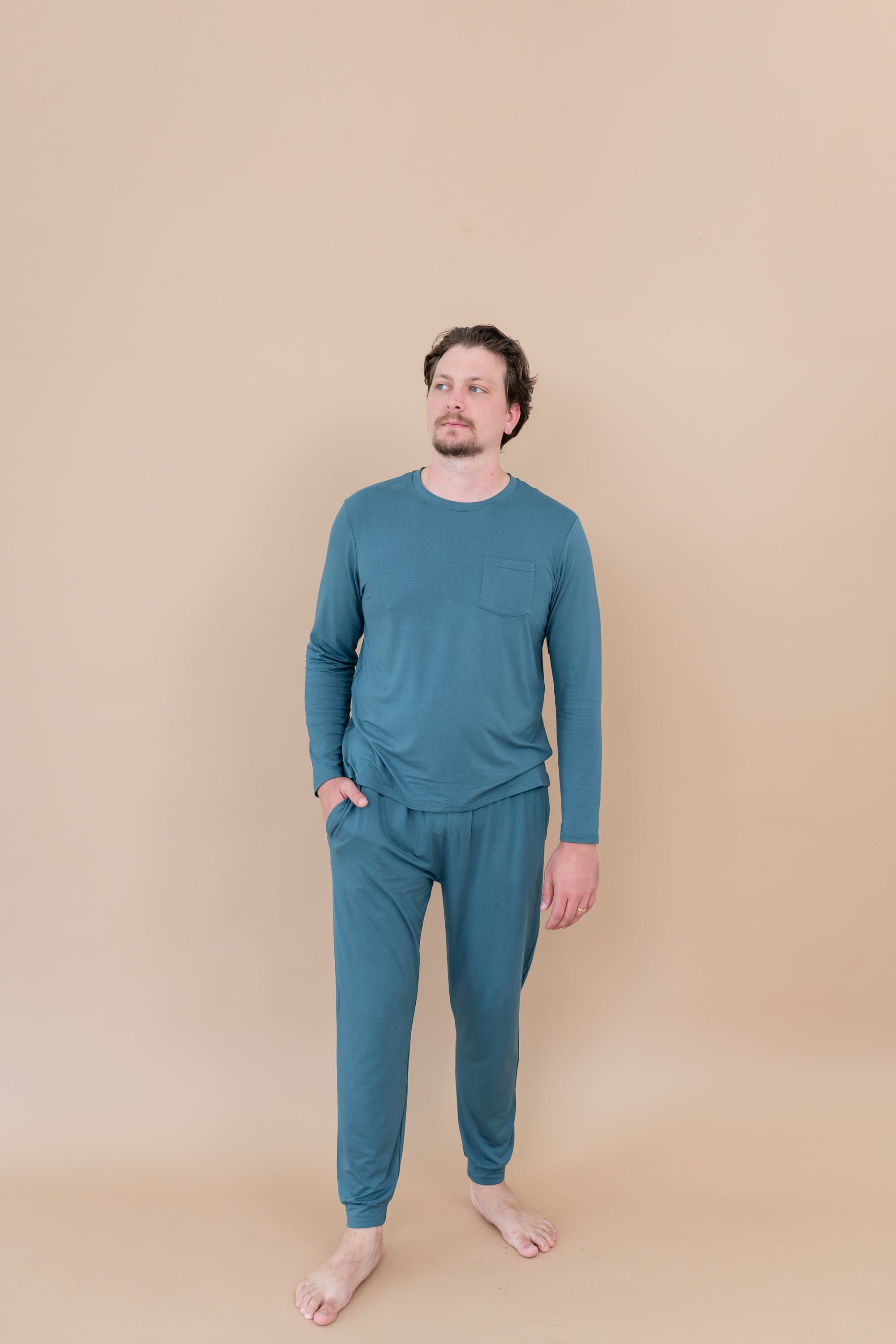 Male model standing with hand in pocket while wearing Men's Jogger Set in Atlantic