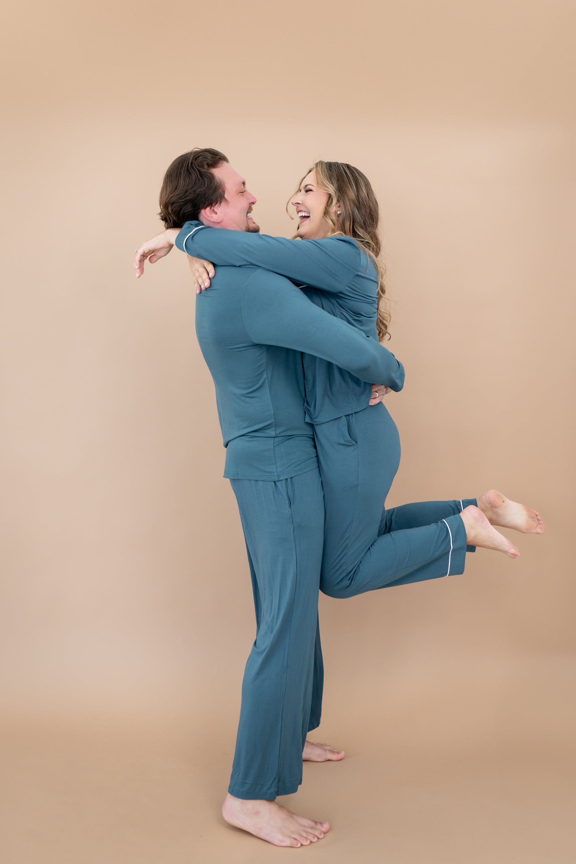 Man wearing the Men's Lounge Pants in Atlantic while holding smiling woman in matching pajama set
