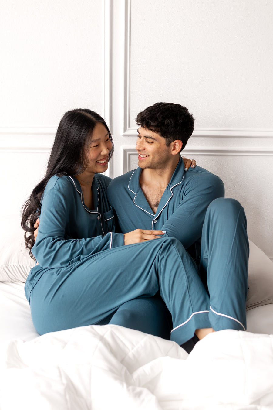 Couple wearing matching bamboo pajamas in a teal color