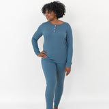 Woman looking to the side with one hand on her hip while modeling the Women’s Ribbed Henley Set in Atlantic