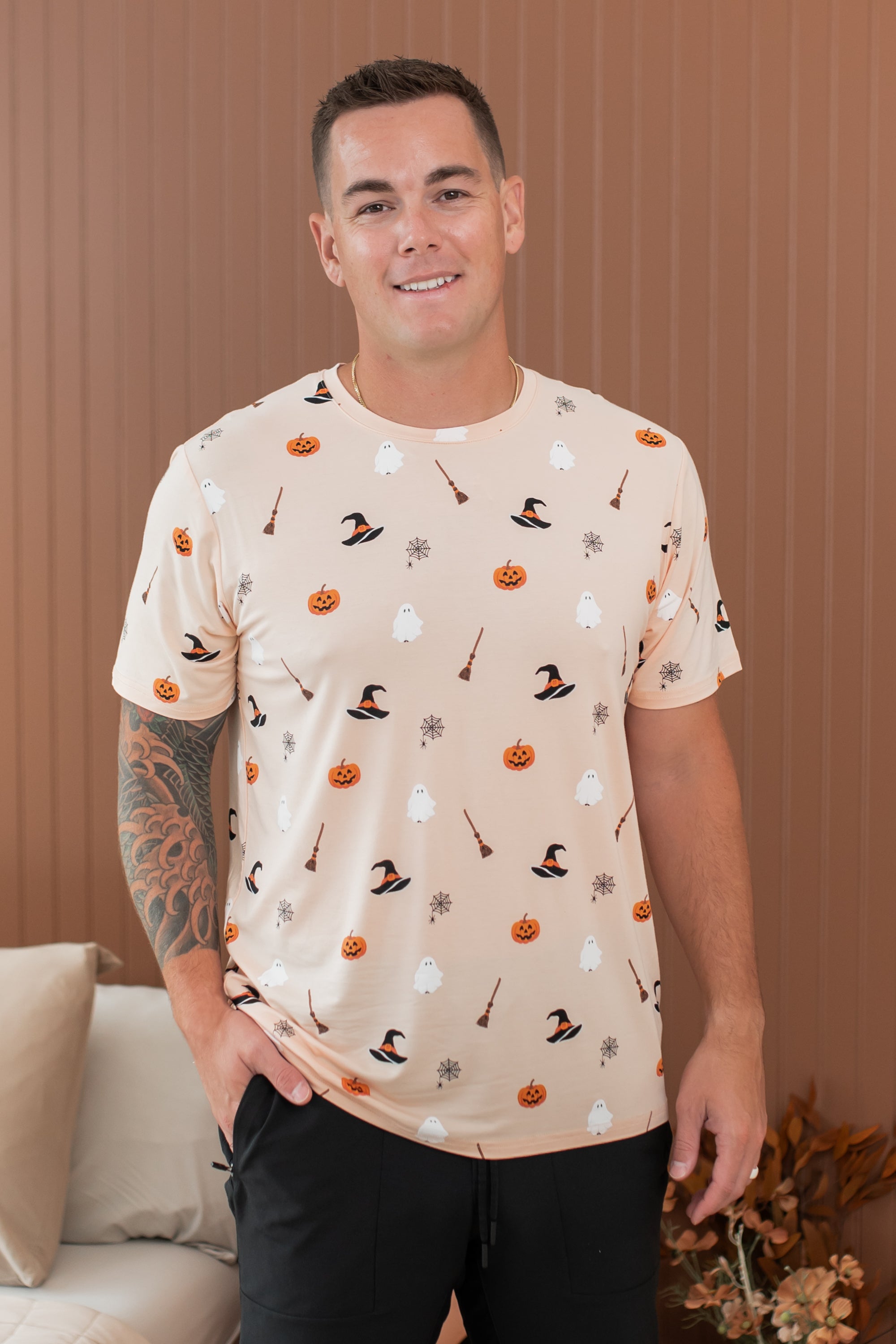 Smiling male model wearing the Kyte Men's Crew Neck in Bewitched paired with black pants