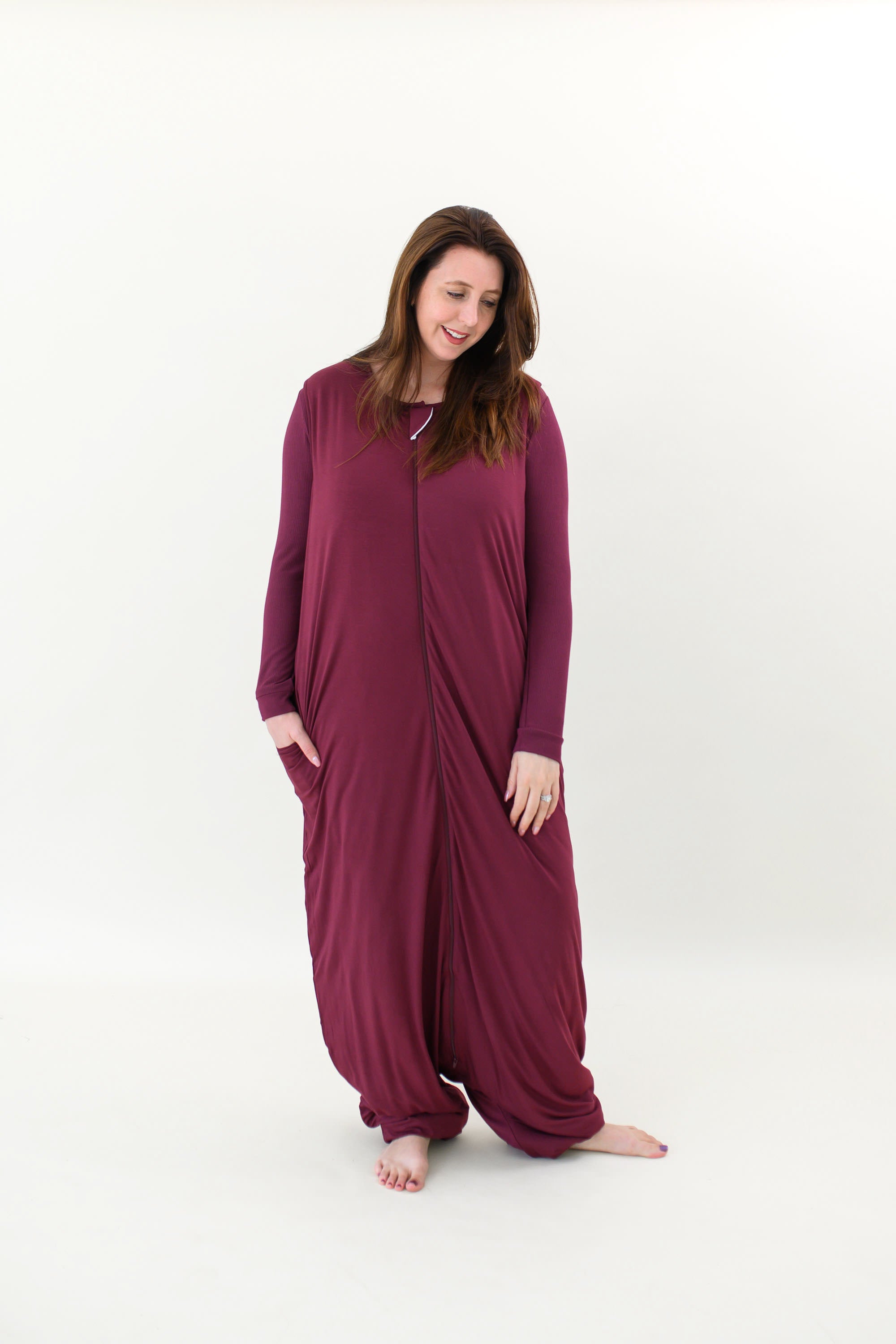 Model looking down to the floor while wearing the Adult Sleep Bag Walker in Burgundy
