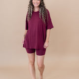 Smiling model walking towards camera while wearing the Women's Biker Short Set in Burgundy