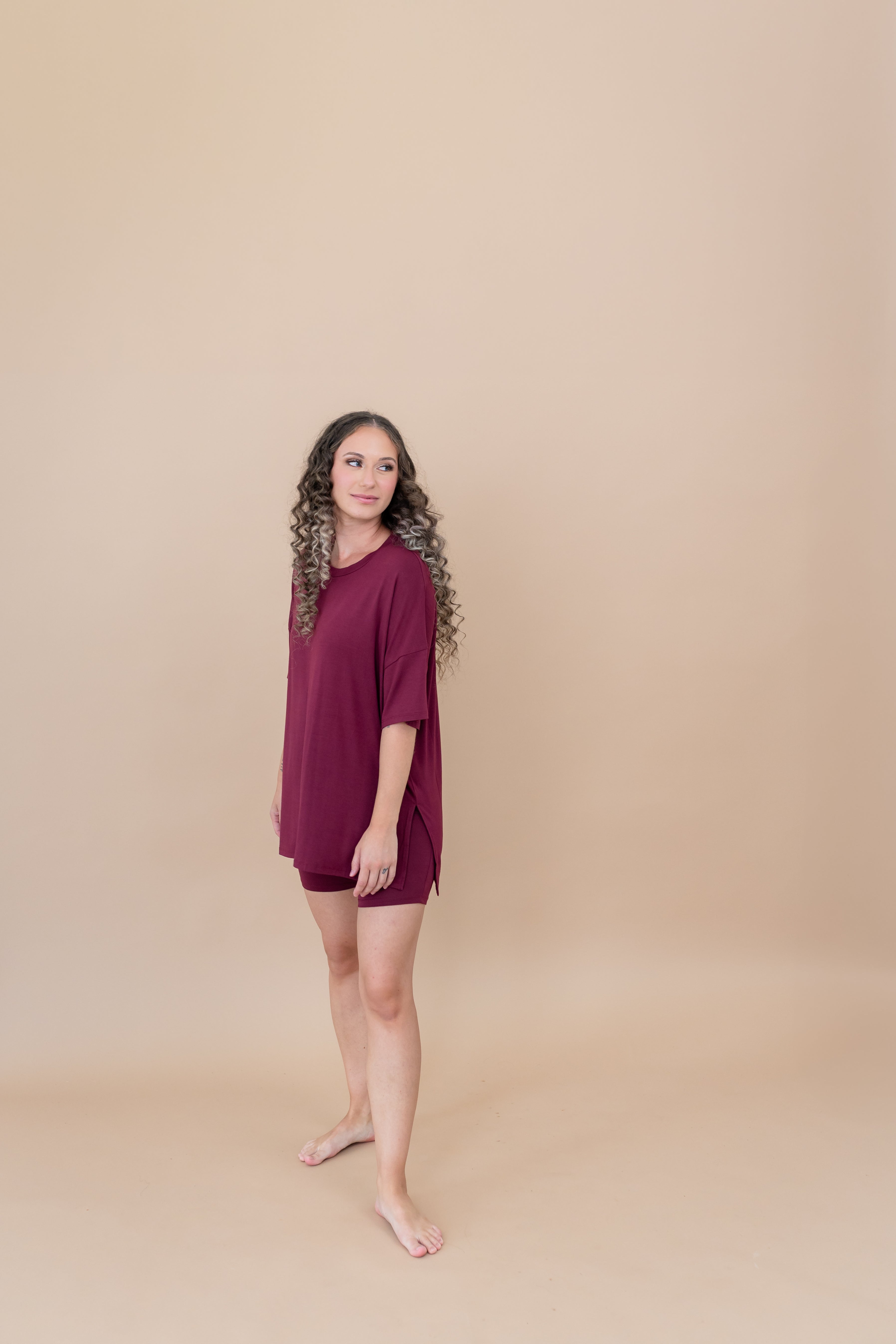 Model looking towards the back while modeling the Kyte Women's Biker Short Set in Burgundy