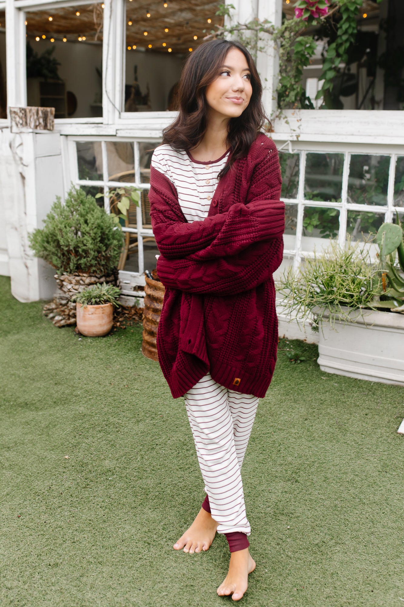 Model wearing the Women's RIbbed Henley Set in Burgundy Stripe and Cable Knit Cardigan in Burgundy while holding arms across her body