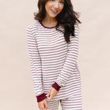 Model smiling wearing the Women's RIbbed Henley Set in Burgundy Stripe while holding one sleeve