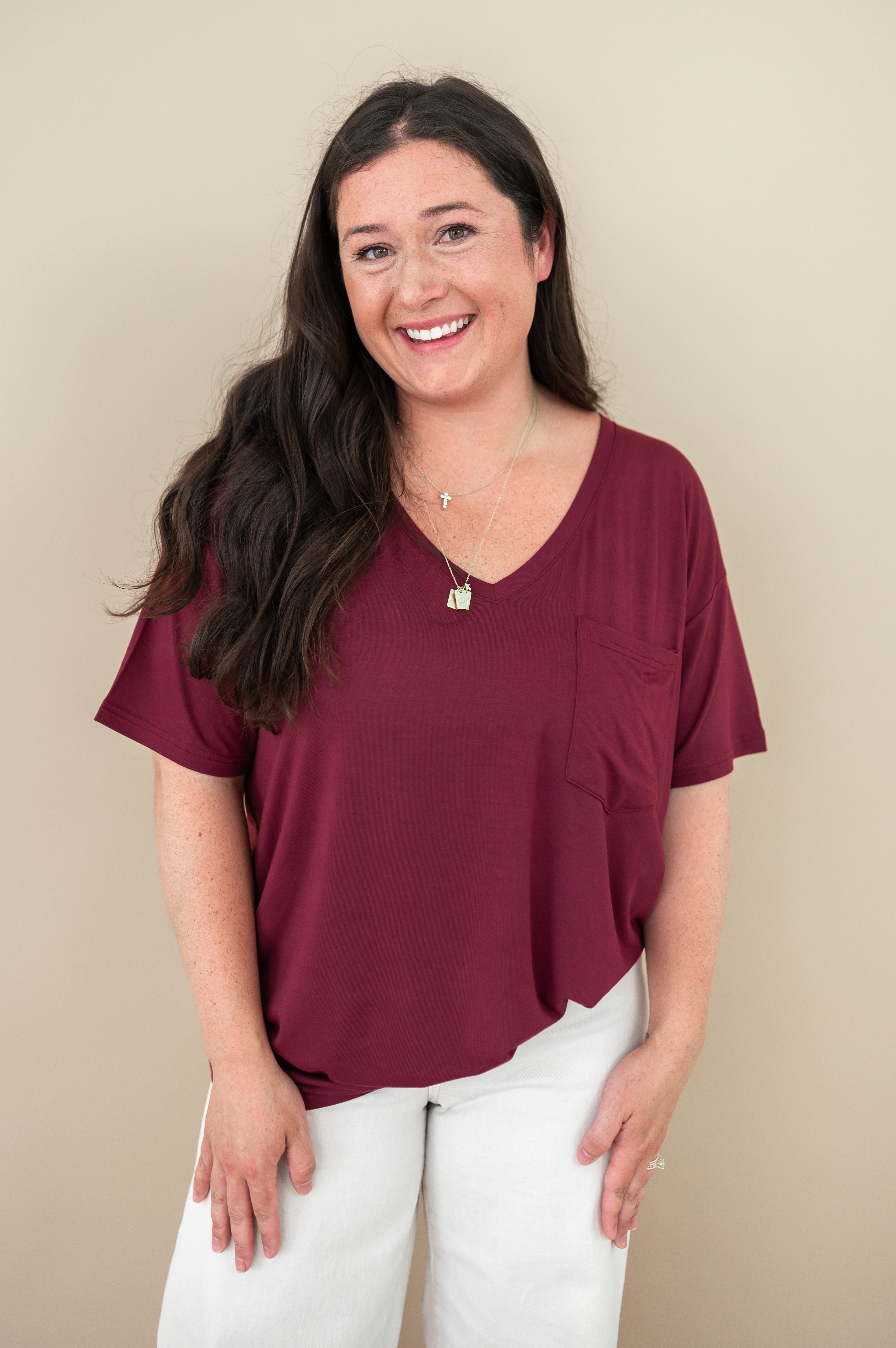 Woman model wearing the V Neck in Burgundy paired with white pants