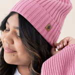 Model wearing the Chunky Knit Adult Ribbed Beanie in Apple Blossom with the Kyte Baby Leather Logo visibile