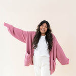 Female wearing the Apple Blossom Chunky Knit Women's Oversized Cardigan paired with a white shirt and white pants