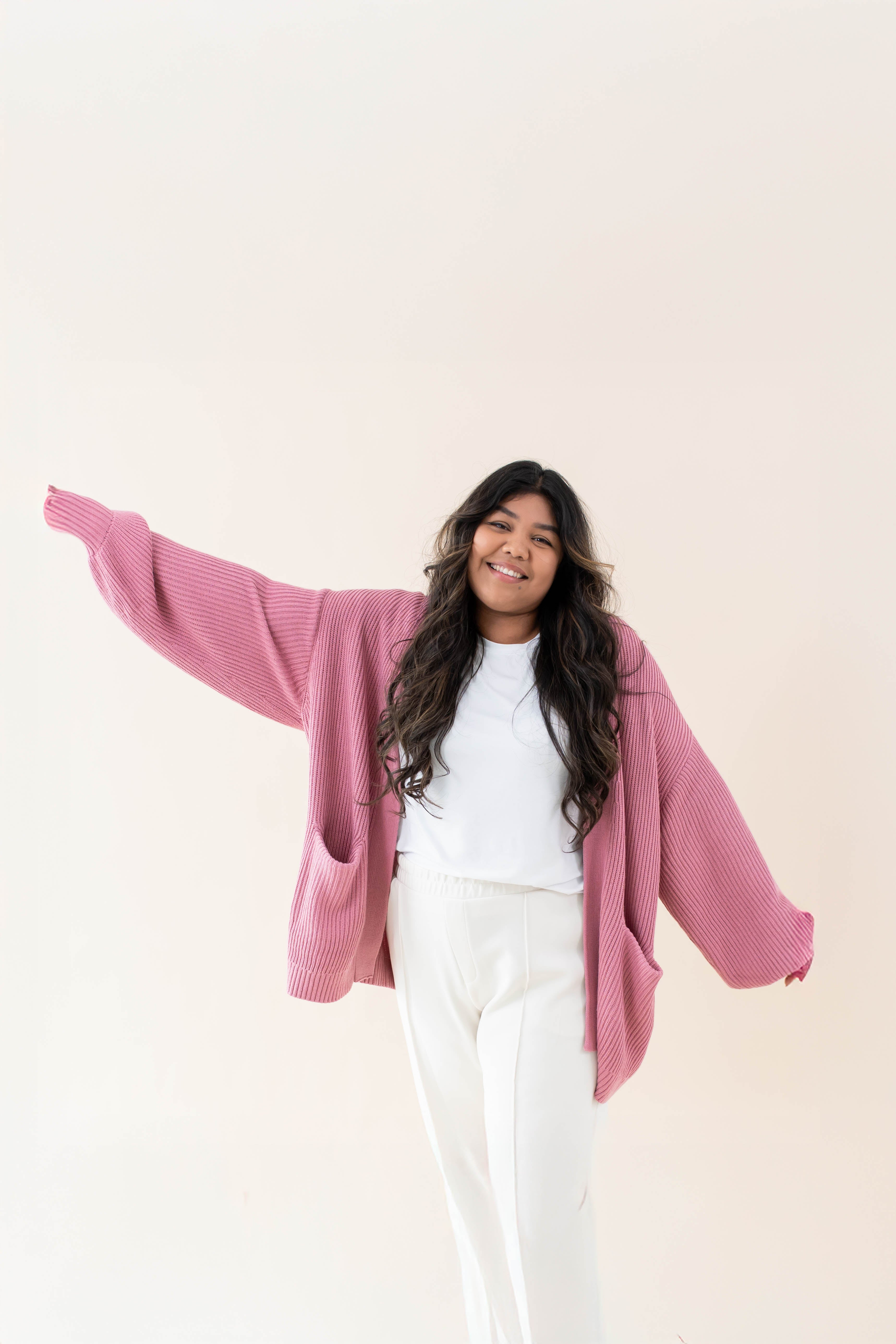 Female wearing the Apple Blossom Chunky Knit Women's Oversized Cardigan paired with a white shirt and white pants