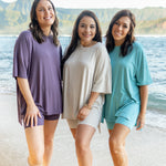 Three models wearing the Women’s Biker Short Lounge Sets in purple, cream, and blue