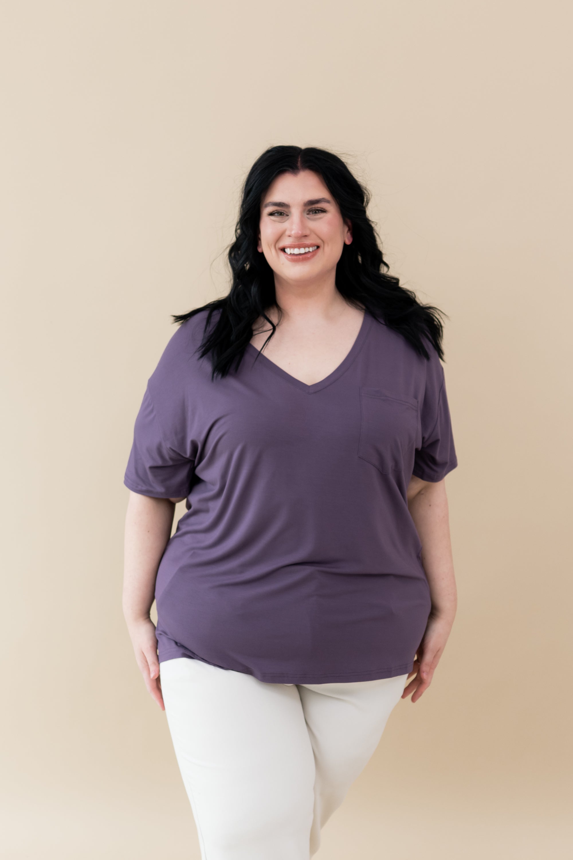 Model wearing Women’s Relaxed Fit V-Neck in Currant paired with white jeans