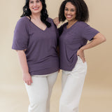 Two models both wearing the Women’s Relaxed Fit V-Neck in Currant and white jeans
