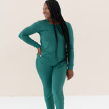 Woman modeling Women's Jogger Pajama Set in Emerald with hand on hip
looking off to the side with braided hair in front of shoulder