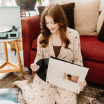 Woman looking at records while modeling the Women's Lounge Robe in Espresso Martini