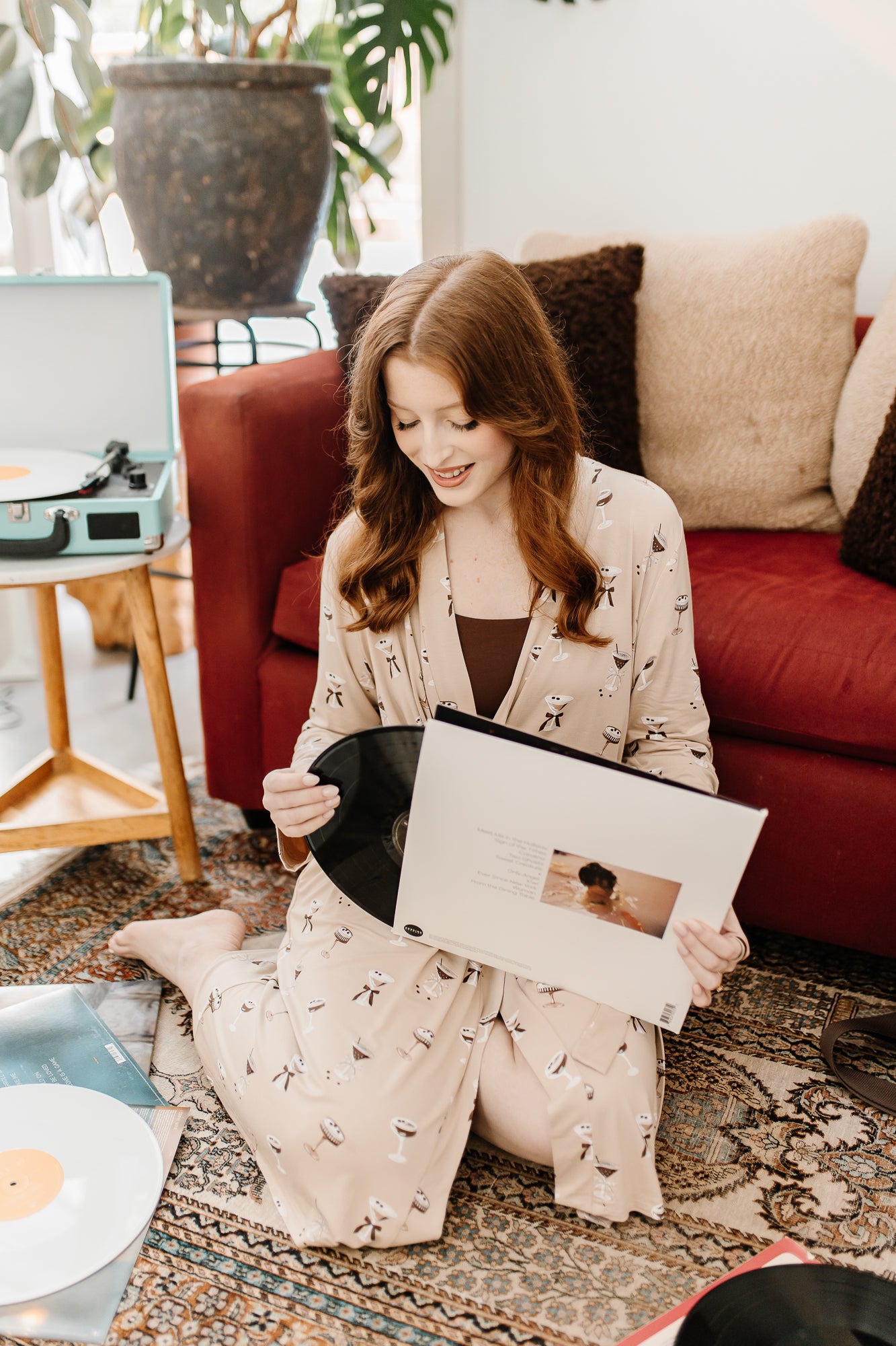 Woman looking at records while modeling the Women's Lounge Robe in Espresso Martini