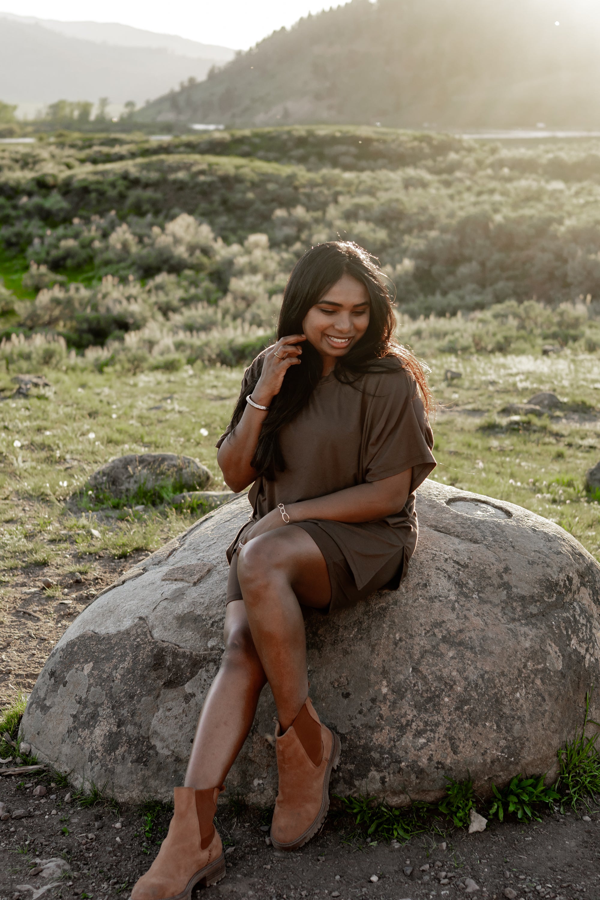 Model sitting on a rock while wearing the Women's Biker Short Set in Espresso