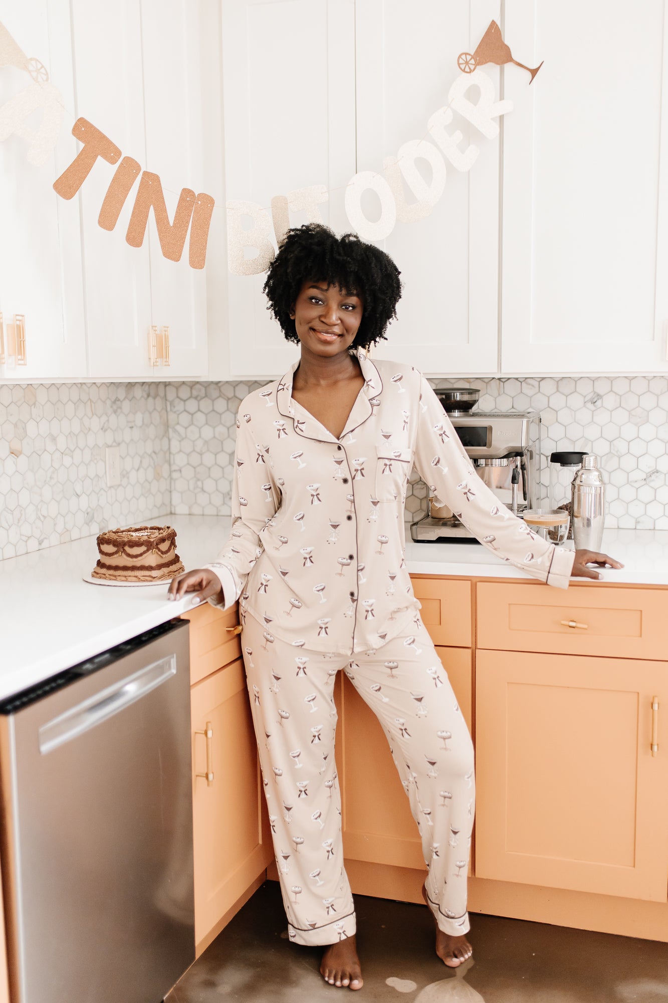 Model standing in front of a counter while modeling the Bamboo Long-Sleeved Women's Pajama Set in Espresso Martini