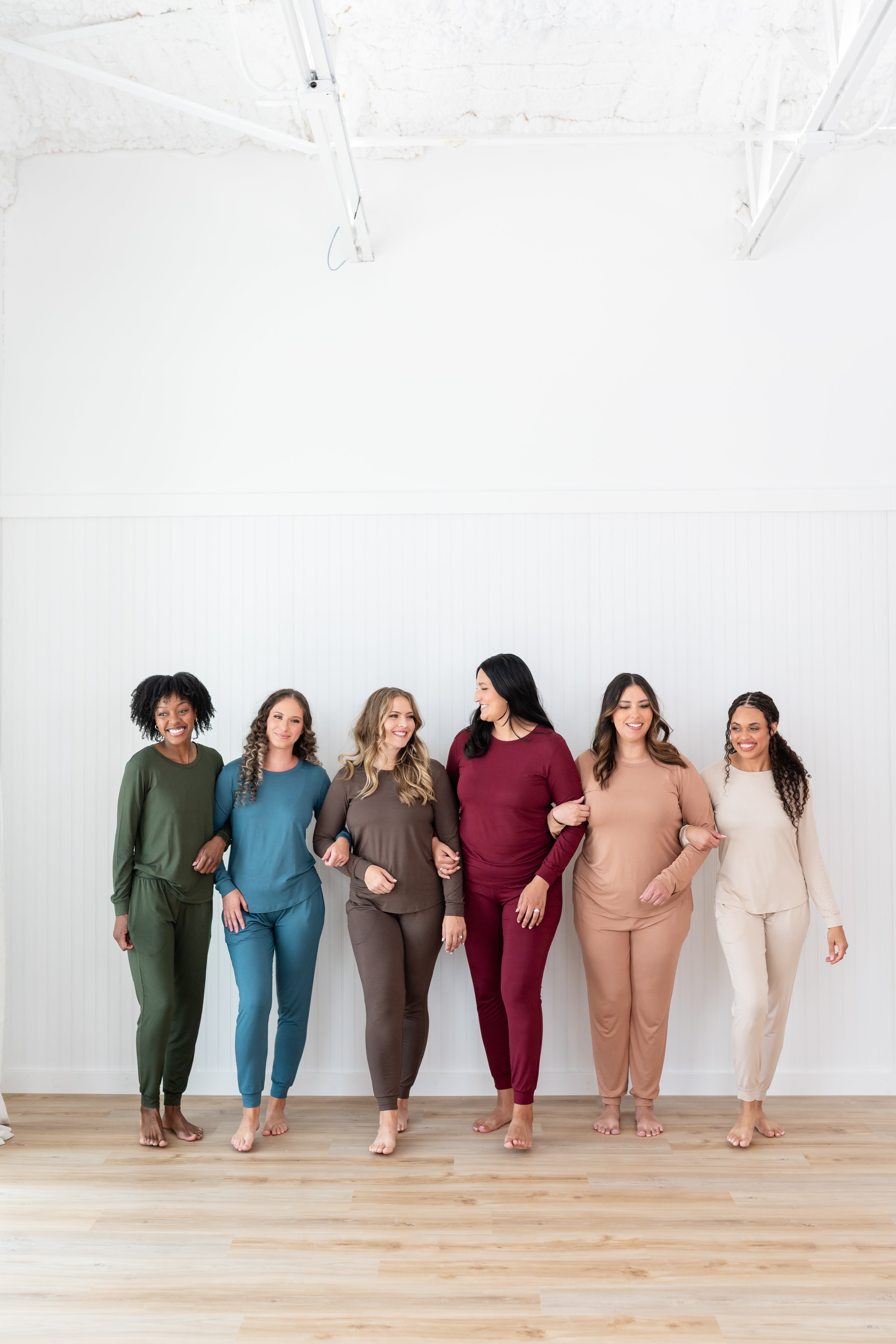 Models with linked arms in Kyte Women's Jogger Sets in Fir, Atlantic, Espresso, Burgundy, Latte and Bisque