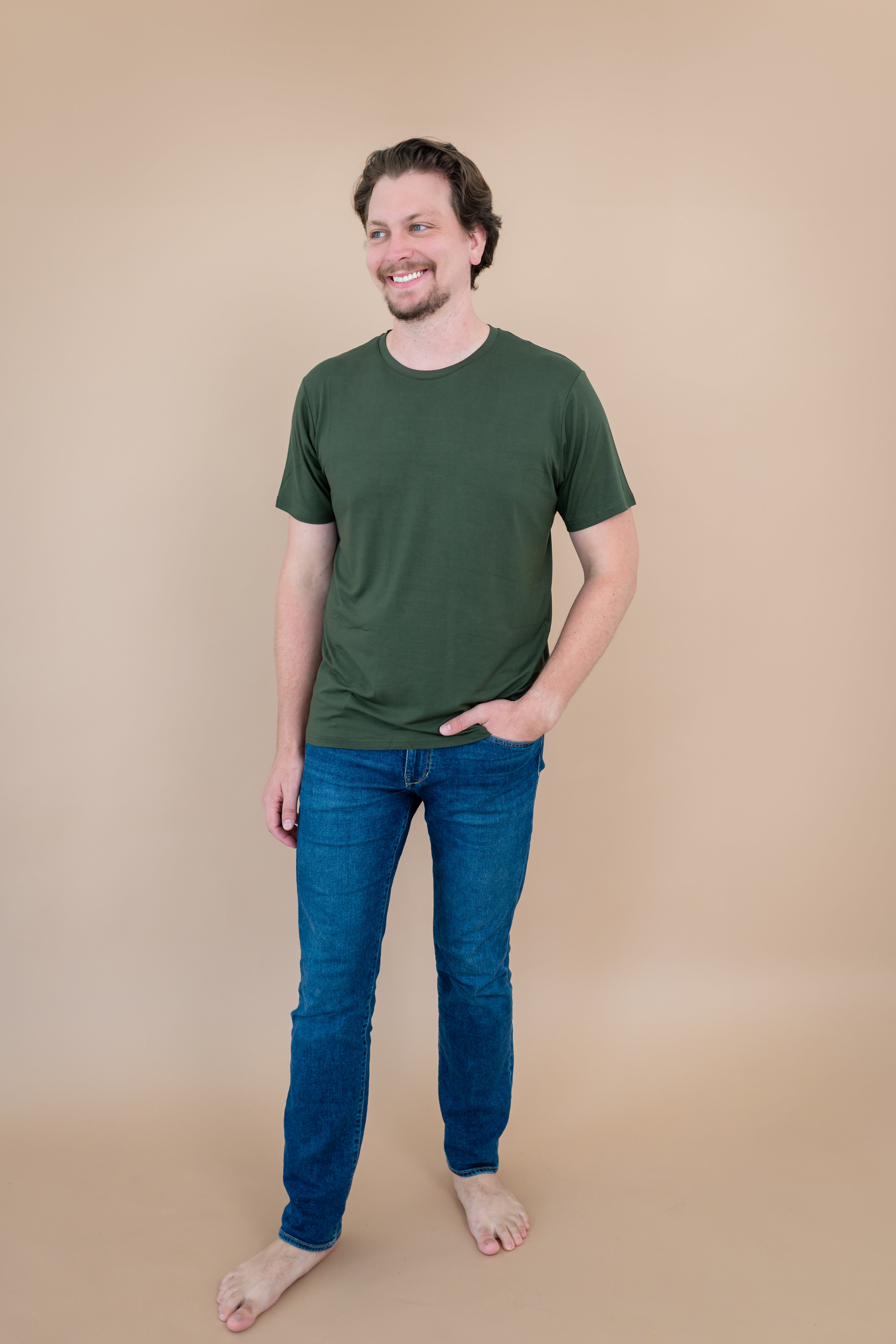 Male model stepping and looking to the side while wearing Kyte Men's Crew Neck Tee in Fir