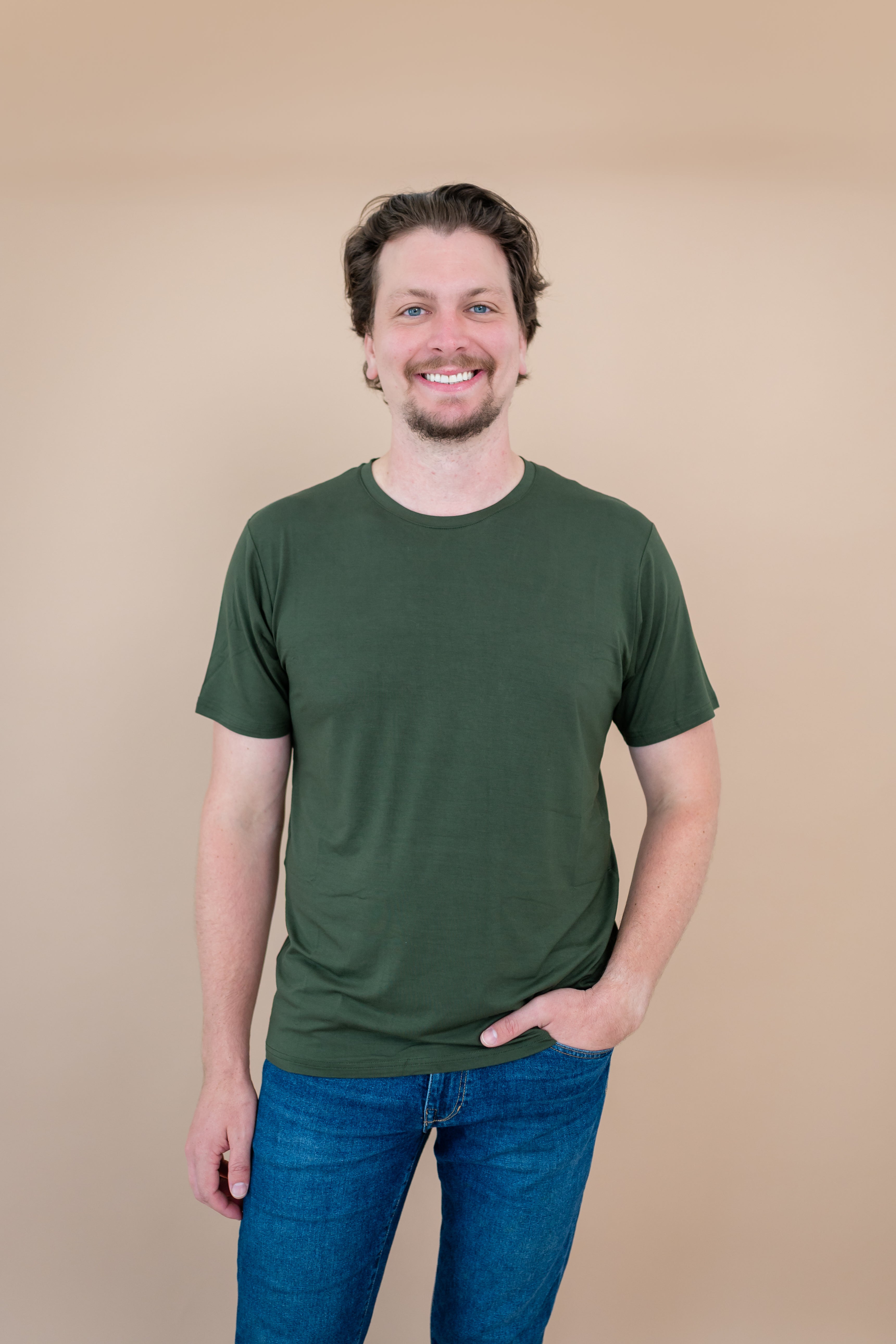 Smiling male model wearing the Kyte Men's Crew Neck Tee in Fir