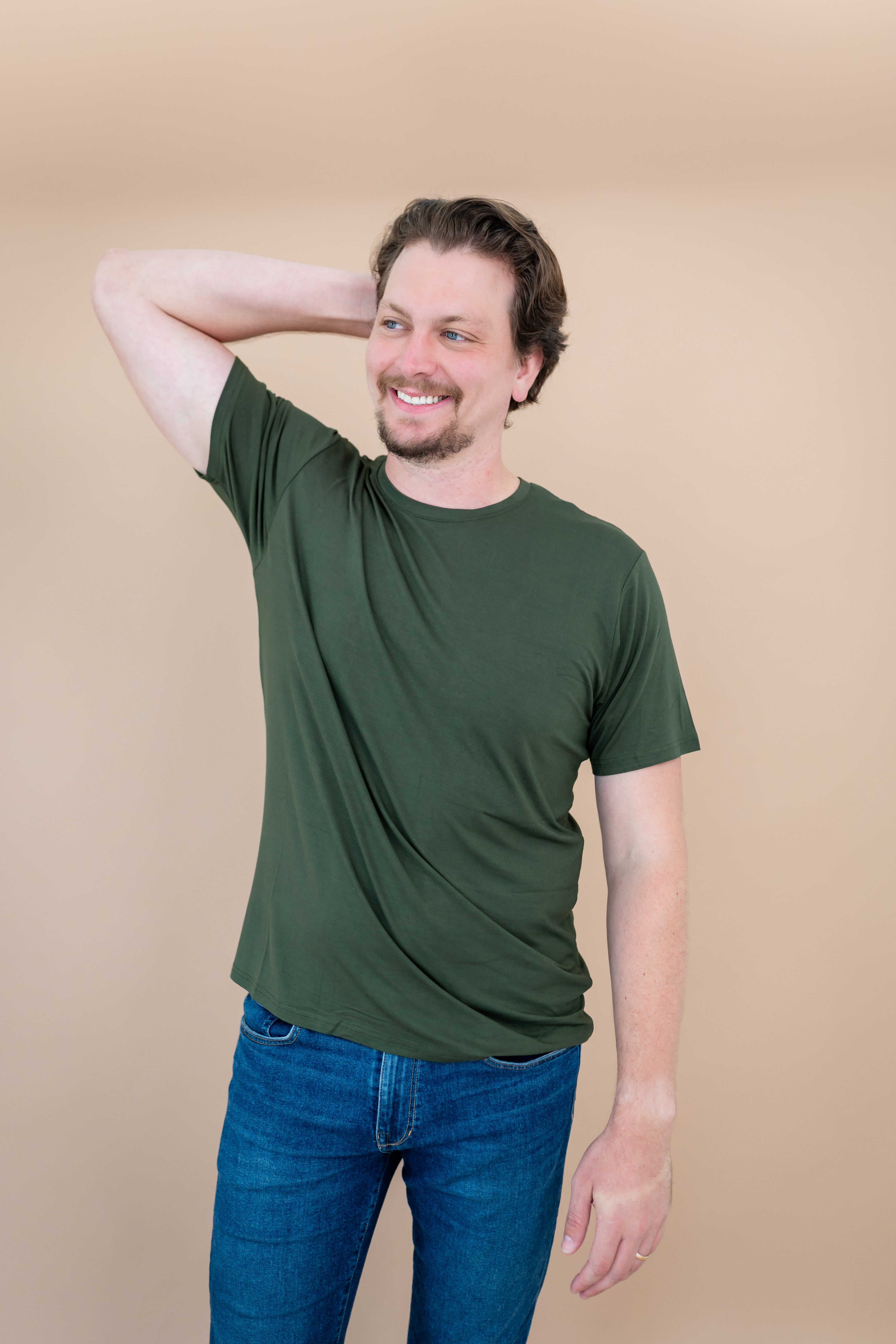 Man with one arm on head while modeling Kyte Men's Crew Neck Tee in Fir