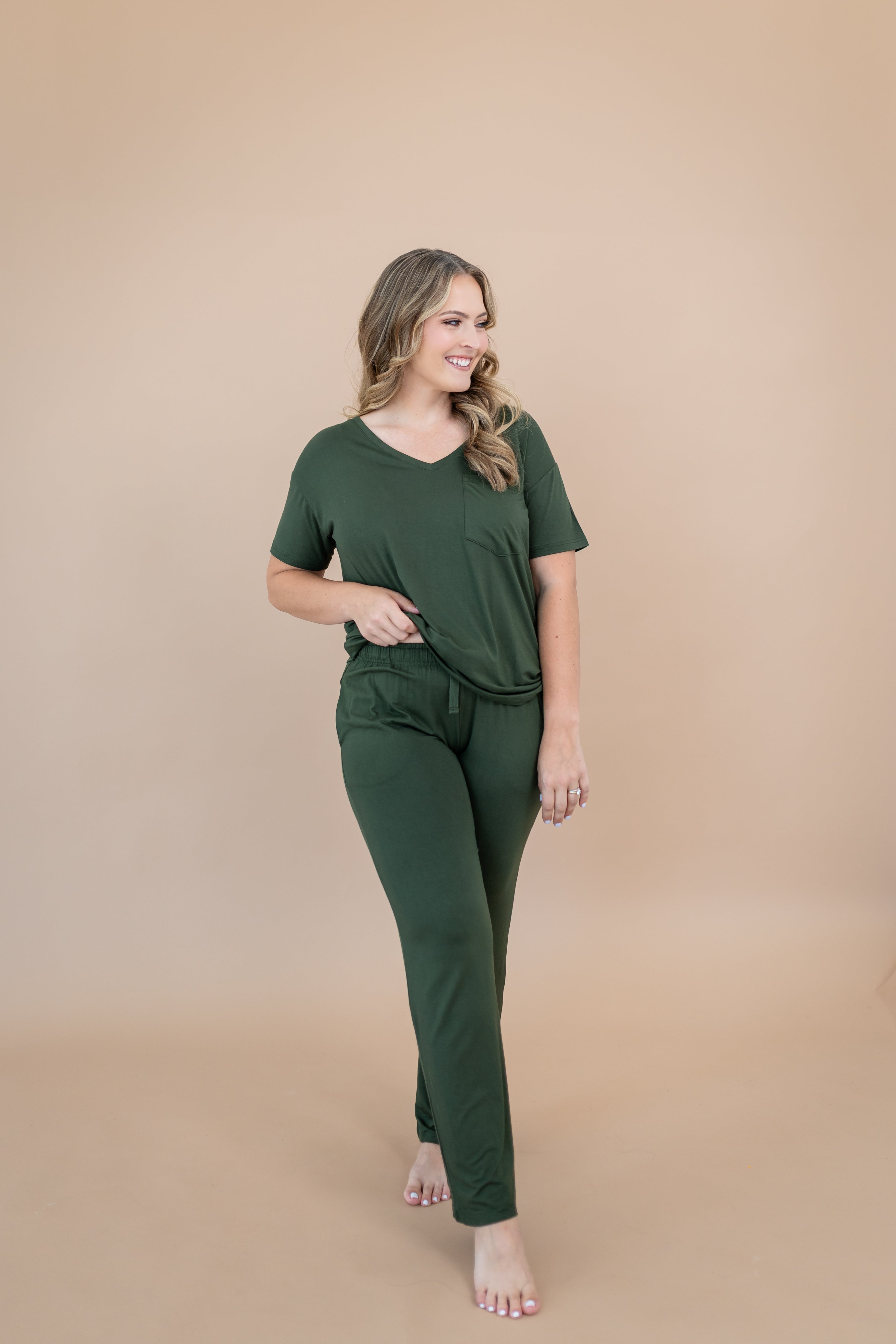 Smiling model wearing the Women's Lounge Pants in Fir and matching Women's V-Neck