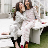 Model in Women’s Ribbed Henley Set in Fir Stripe whispering to model in Women’s Ribbed Henley Set in Burgundy Stripe