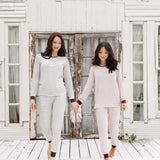 Models holding hands looking down while wearing the Women’s Ribbed Henley Set in Fir Stripe and Burgundy Stripe