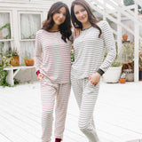 Models standing on steps while wearing the Women's RIbbed Henley Set in Burgundy Stripe and Fir Stripe