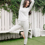 Model in Women’s Ribbed Henley Set in Fir Stripe, standing on one leg with arms overhead.