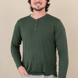 Smiling male model wearing the Kyte Men's Long Sleeve Henley Top in Fir