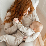 Woman nursing baby wearing the Women's French Terry Nursing Hoodie in Almond