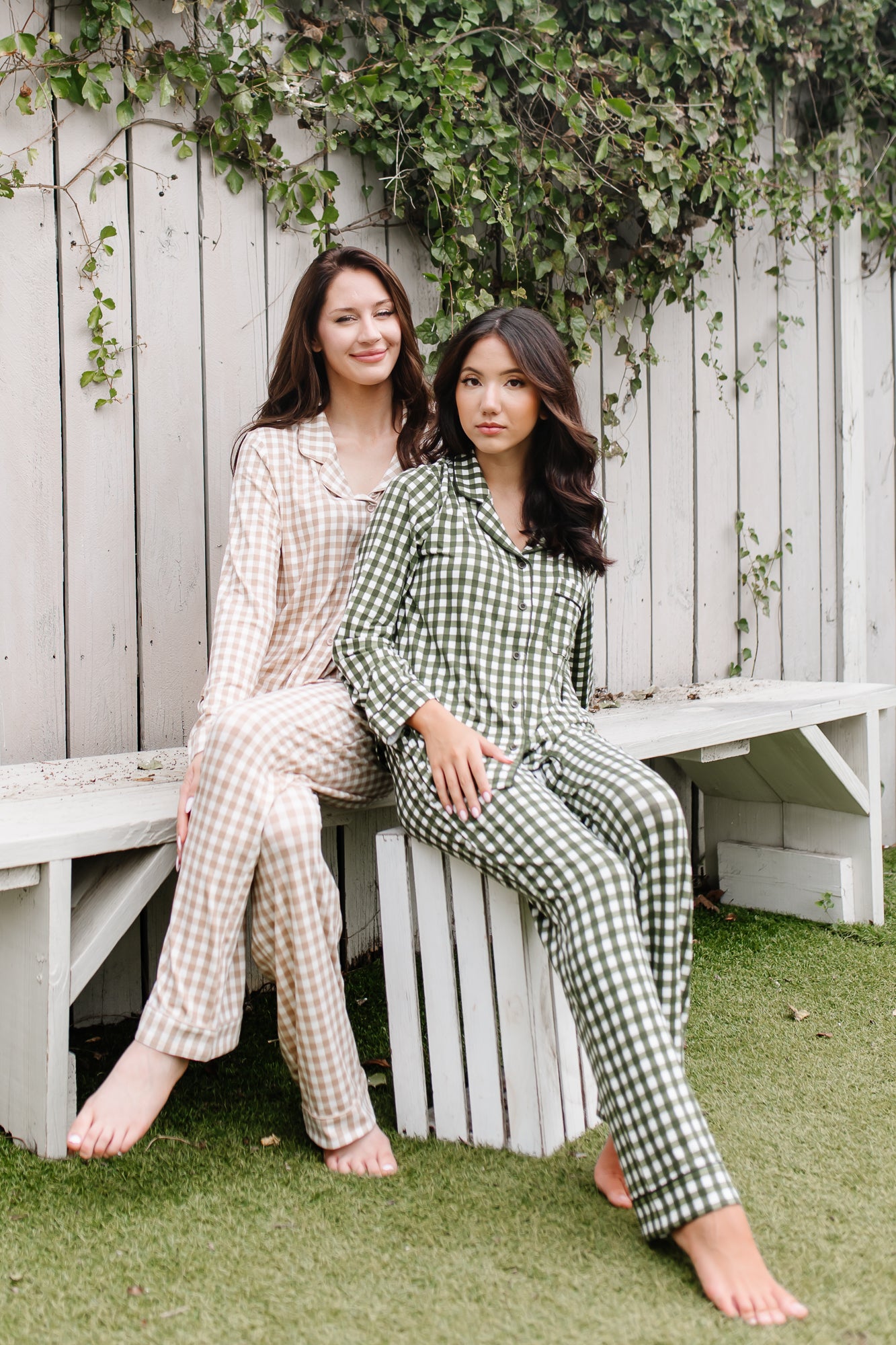 Models sitting on a bench wearing the Women's Long Sleeve Pajama Set in Gingham Fir and Gingham Bisque