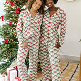 Models standing in front of a Christmas tree with arms around each other while wearing matching Bamboo Long-Sleeved Women's Pajama Set in Holiday Bow