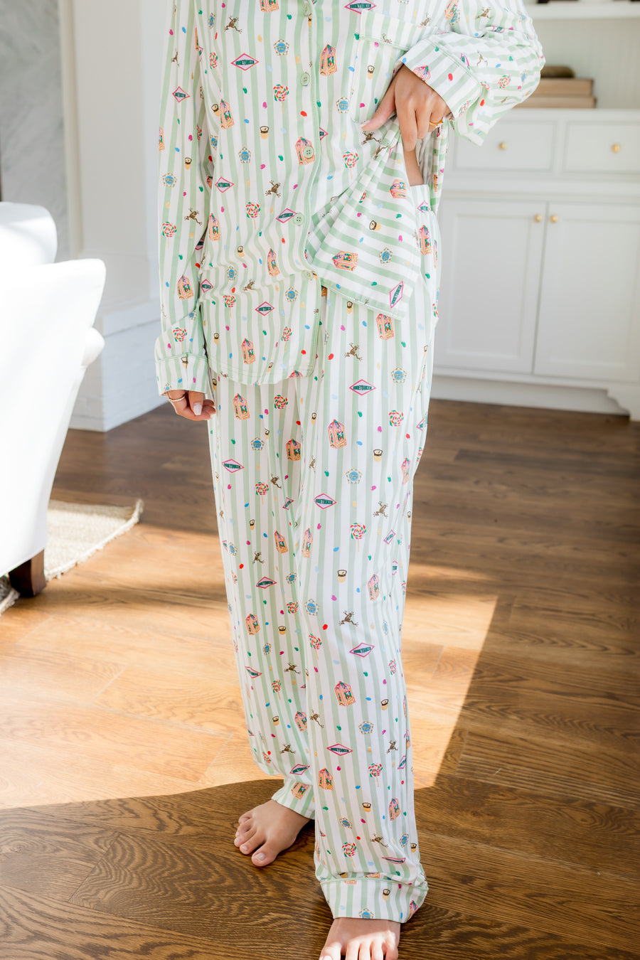Person wearing Long-Sleeved Women's Pajama Set with colorful Harry Potter patterns on a green and white striped fabric.