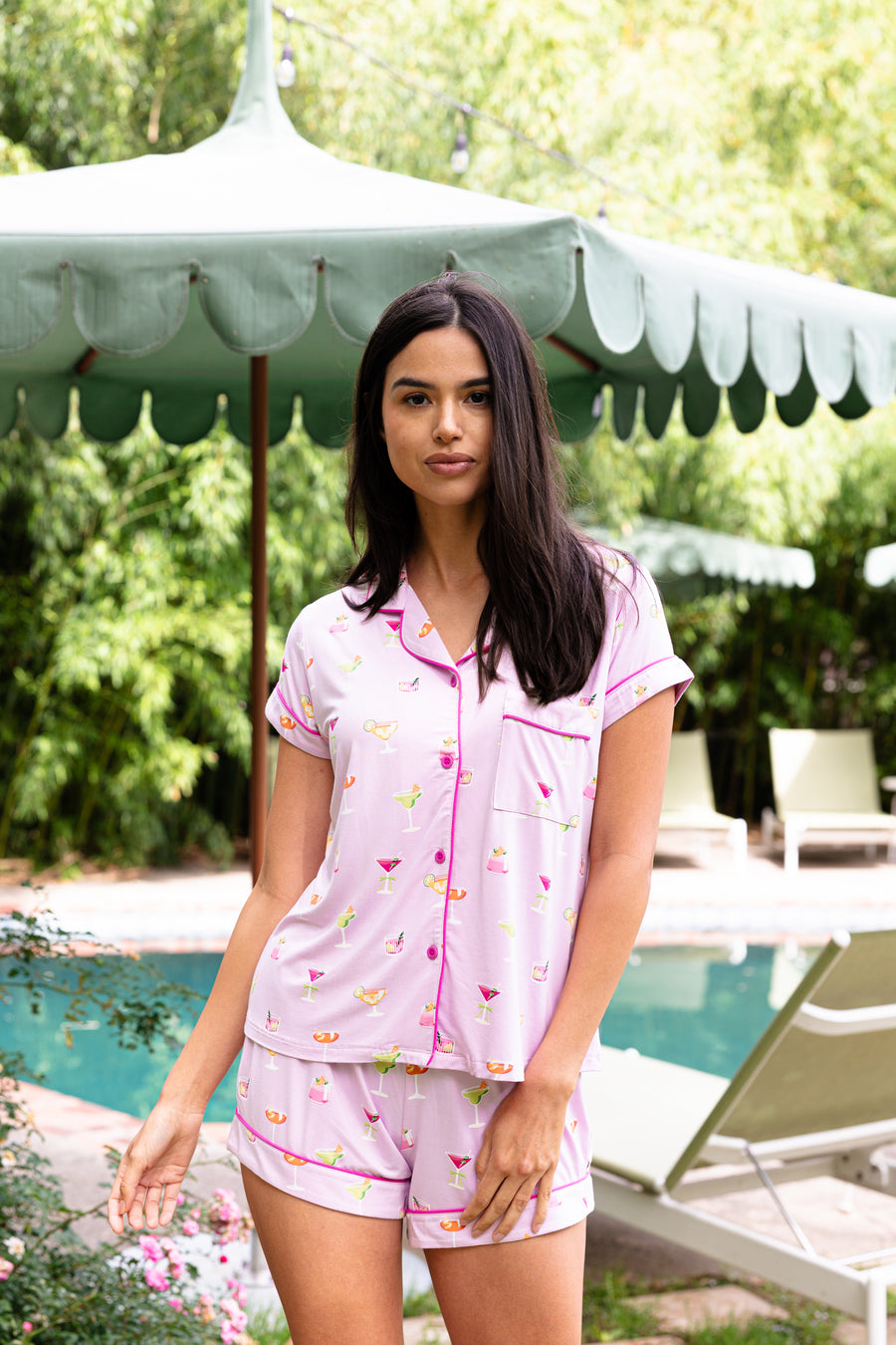 Close up of the model wearing the Women's Short Sleeve Pajama Set in Cocktail in front of a pool umbrella