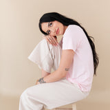 woman sitting on a stool modeling Women's Crew Neck Tee in Sakura