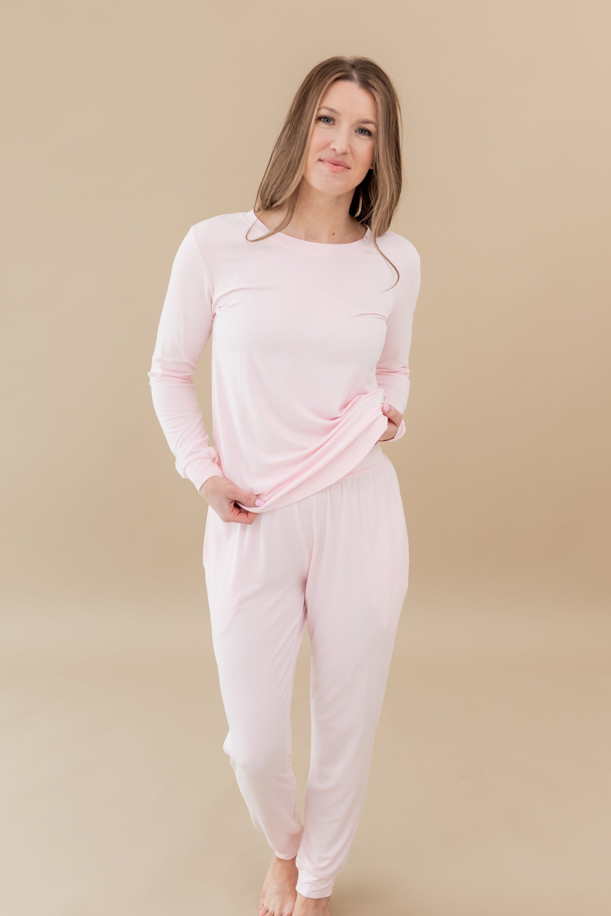 Woman modeling Women's Jogger Pajama Set in Sakura slightly lifting top to show elastic band of jogger pant