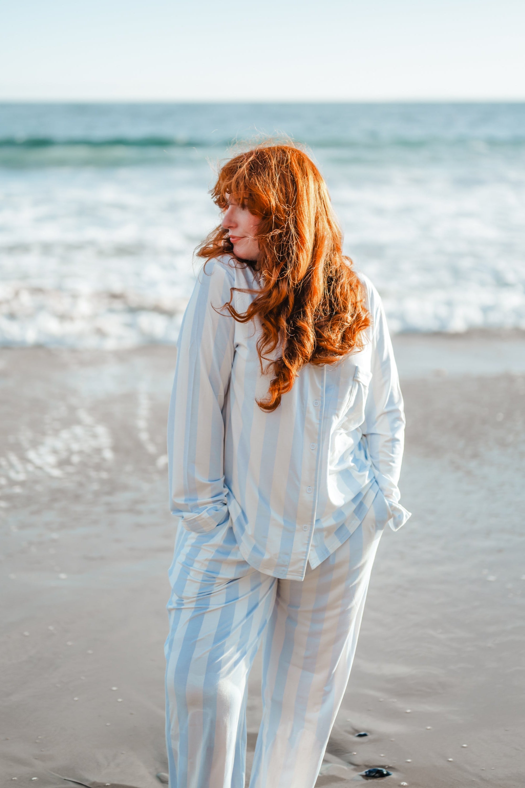 Woman modeling big mist stripe pajamas on the beach