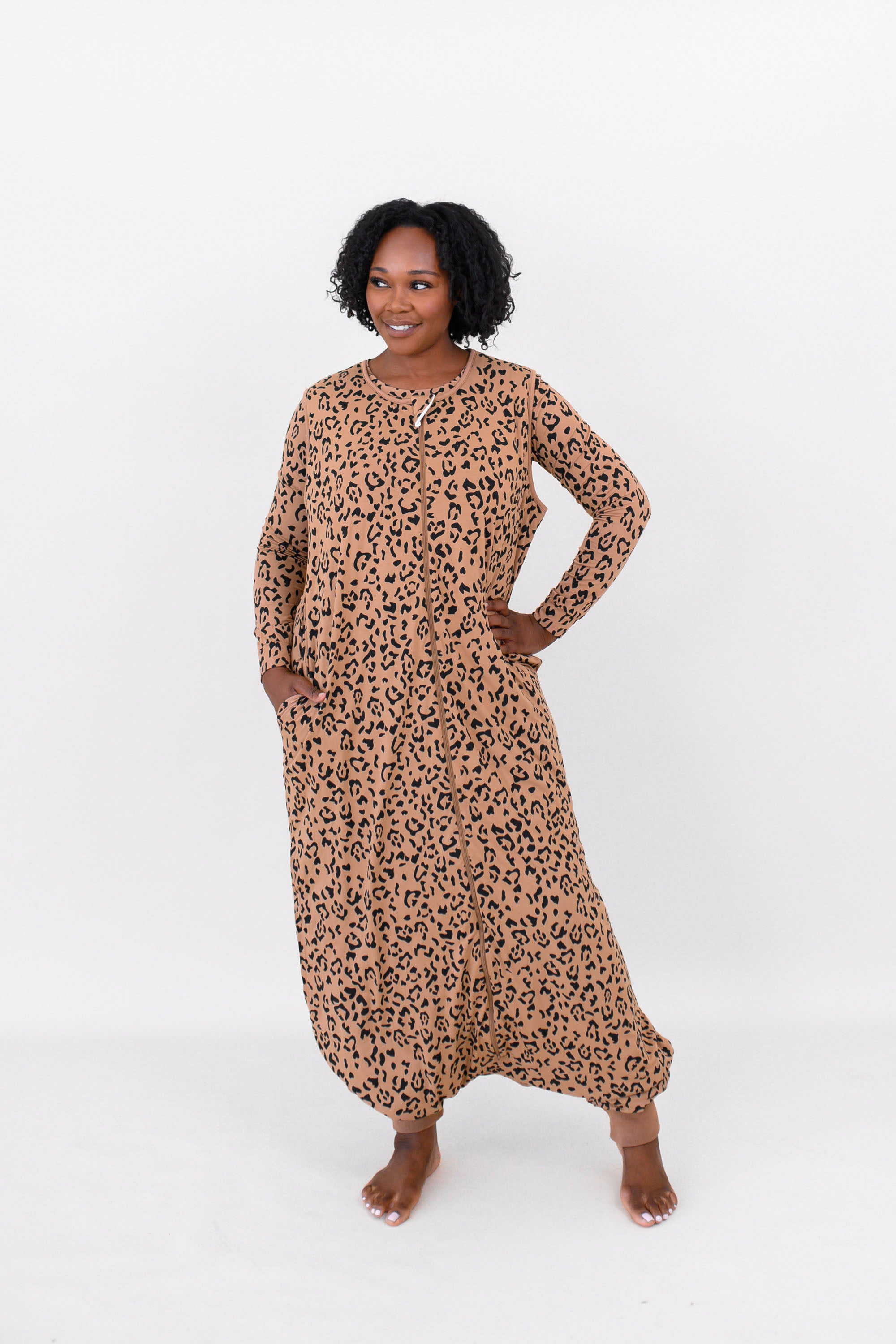 Woman modeling the Kyte Adult Sleep Bag Walker in Latte Leopard with matching top layered beneath it