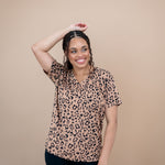 Model with one arm up while wearing the Women's V Neck Tee in Latte Leopard